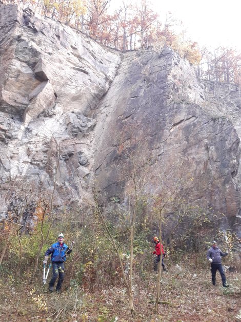Menschen mit Werkzeugen vor hoher Felswand